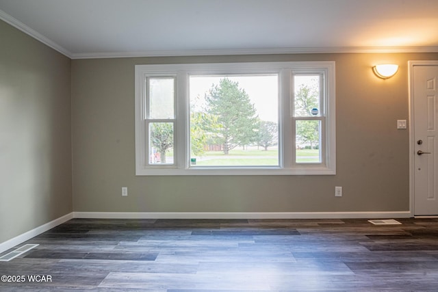 spare room with ornamental molding and dark hardwood / wood-style flooring