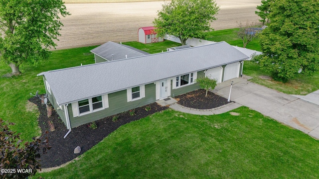 exterior space featuring a garage, a front yard, and a storage shed