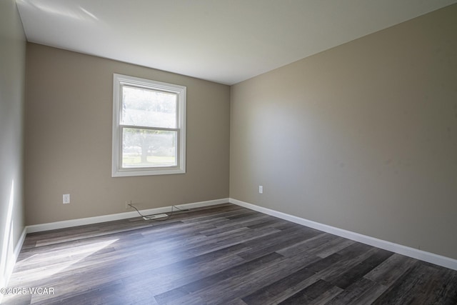 unfurnished room with dark wood-type flooring