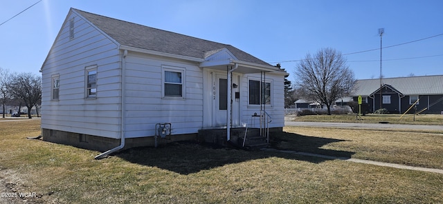 bungalow-style house with a front lawn and a shingled roof