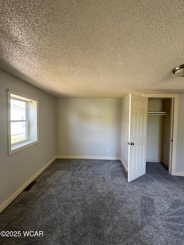 512 W N St, Kenton, OH 43326 - unfurnished bedroom featuring dark colored carpet, a textured ceiling, a closet, and baseboards