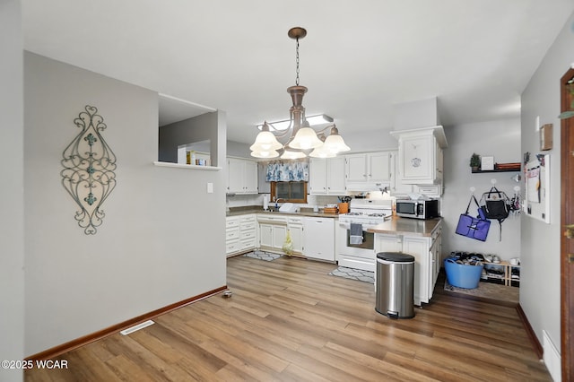 2432 Kunneke Ave, Lima, OH 45805 - kitchen with white gas stove, stainless steel microwave, a chandelier, light wood-style flooring, and a sink