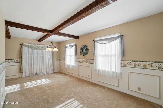 2432 Kunneke Ave, Lima, OH 45805 - unfurnished dining area with wainscoting, a chandelier, beamed ceiling, light carpet, and a decorative wall