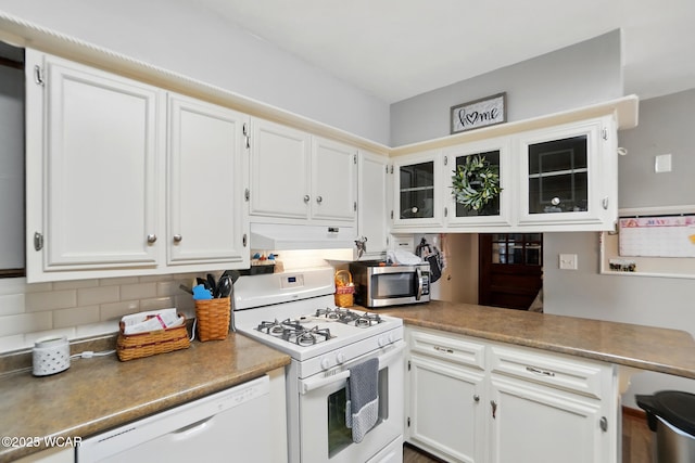 2432 Kunneke Ave, Lima, OH 45805 - kitchen with white appliances, white cabinetry, under cabinet range hood, tasteful backsplash, and glass insert cabinets