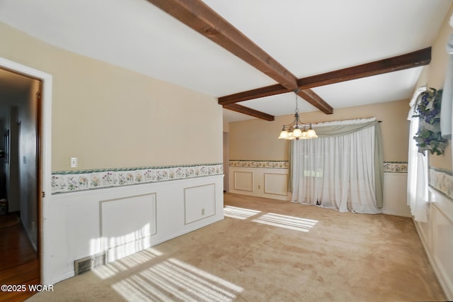 2432 Kunneke Ave, Lima, OH 45805 - empty room with beamed ceiling, a chandelier, wainscoting, and light carpet