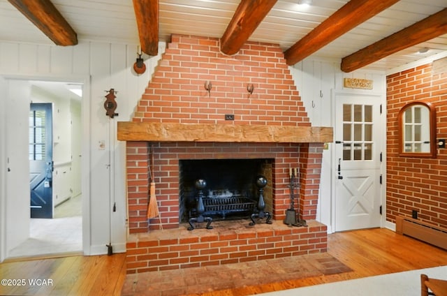 2297 June Dr, Lima, OH 45805 - living room featuring hardwood / wood-style flooring, a wooden ceiling with exposed beams, a brick fireplace, and a baseboard heating unit