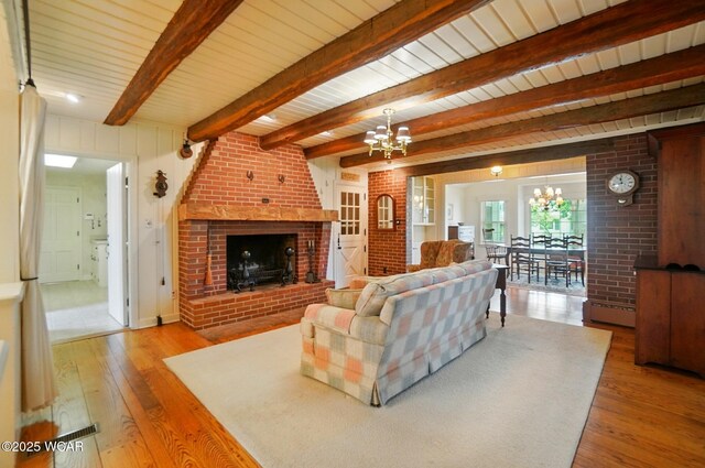 2297 June Dr, Lima, OH 45805 - living room featuring a chandelier, hardwood / wood-style floors, a fireplace, and a wood ceiling with exposed beams
