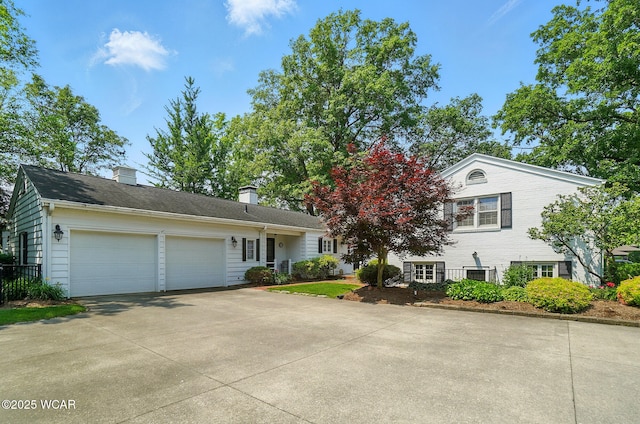 2297 June Dr, Lima, OH 45805 - view of front of home with concrete driveway, an attached garage, and a chimney