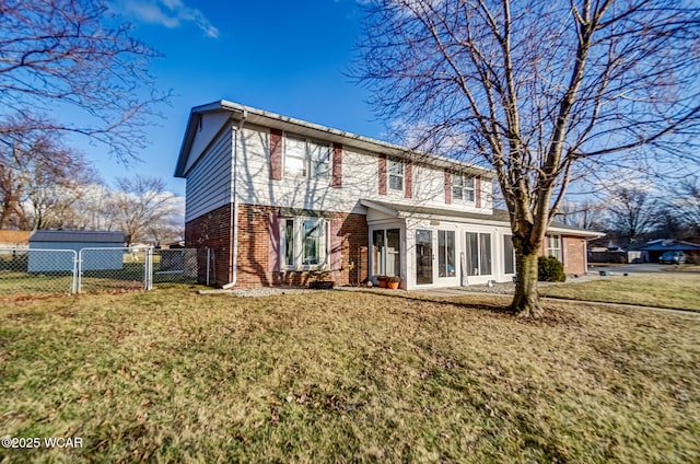 view of front of house featuring a front yard, a gate, brick siding, and fence