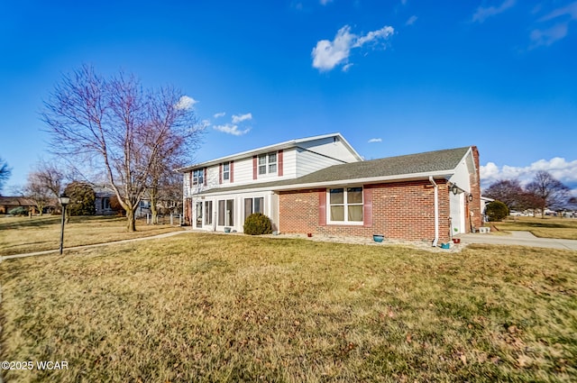 exterior space featuring a front yard, concrete driveway, brick siding, and an attached garage