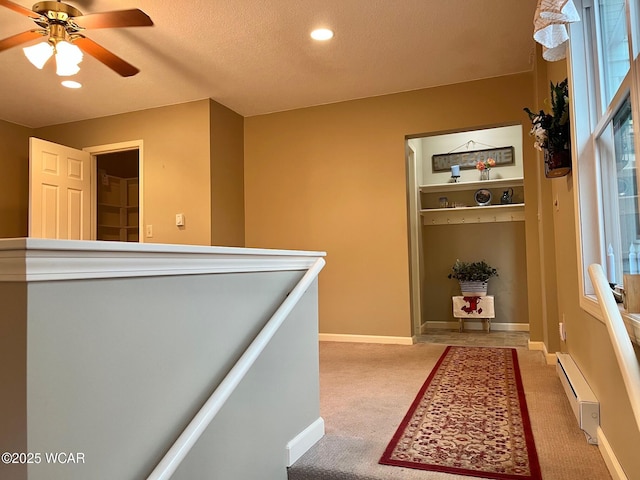 hall featuring carpet floors, a baseboard radiator, and a textured ceiling