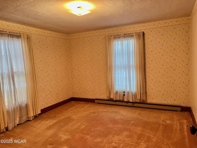 empty room featuring plenty of natural light, carpet floors, and baseboard heating