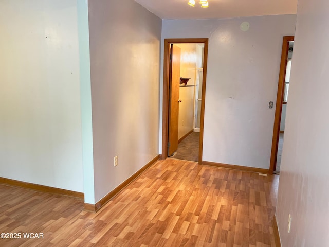 hall featuring baseboards and light wood finished floors