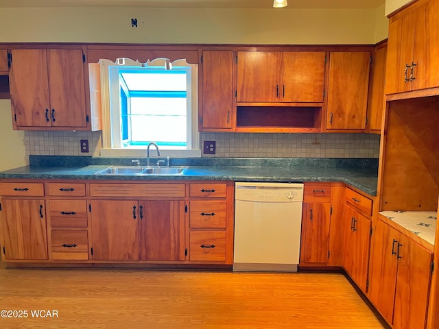 kitchen with light wood-style flooring, a sink, dishwasher, open shelves, and dark countertops