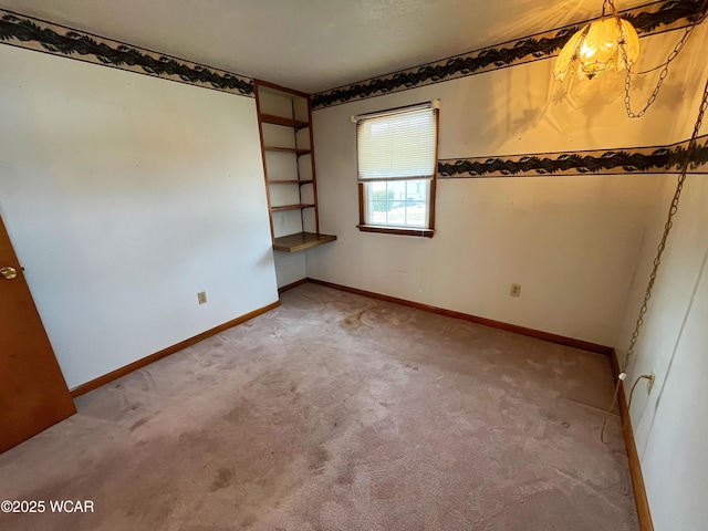 unfurnished room with baseboards and light colored carpet