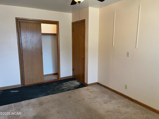 unfurnished bedroom with ceiling fan, a closet, dark carpet, and baseboards