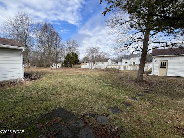 view of yard featuring fence and an outdoor structure