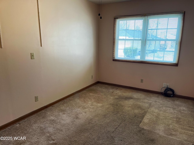 carpeted spare room with baseboards