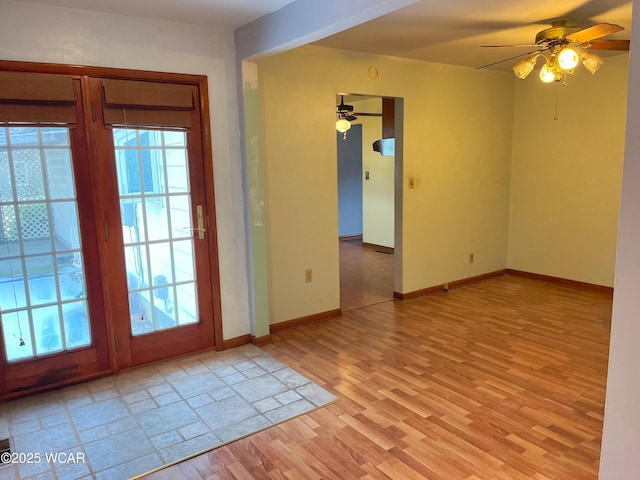 doorway to outside featuring light wood-type flooring, a ceiling fan, baseboards, and a wealth of natural light