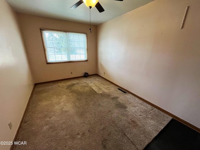 spare room featuring light carpet, visible vents, and baseboards