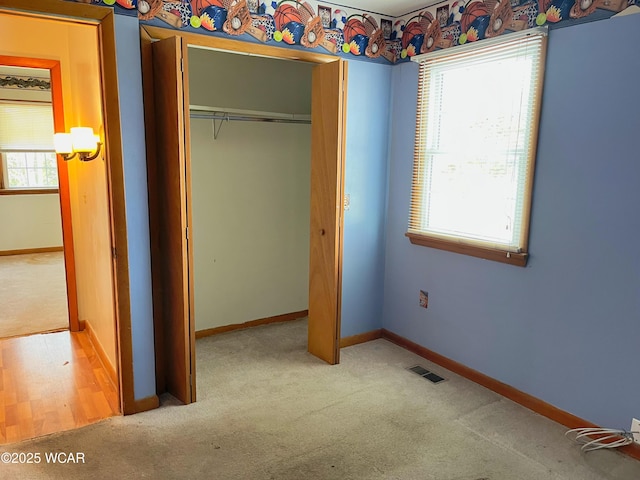 unfurnished bedroom featuring carpet floors, a closet, visible vents, and baseboards