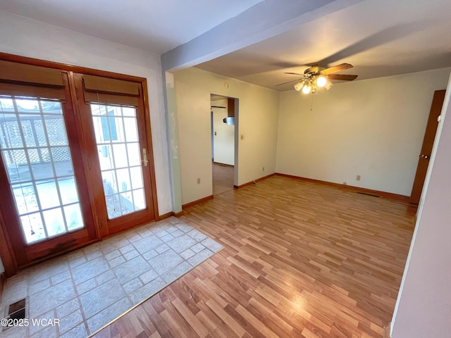 unfurnished room with a healthy amount of sunlight, ceiling fan, light wood-style flooring, and baseboards