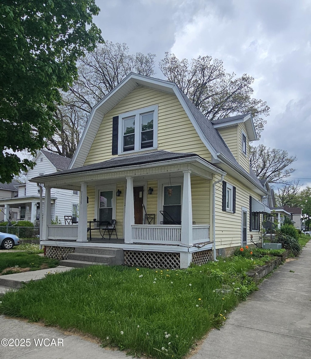 1179 W High St, Lima, OH 45805 - dutch colonial featuring covered porch, roof with shingles, and a gambrel roof