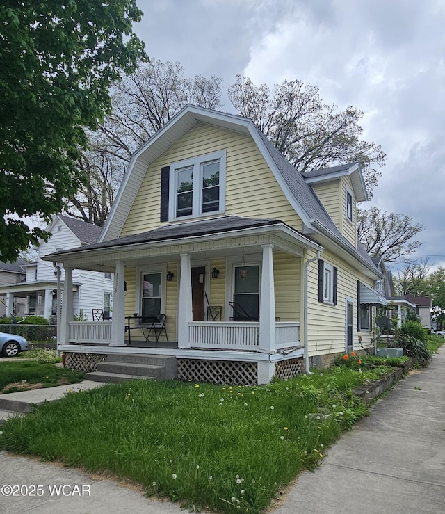 1179 W High St, Lima, OH 45805 - dutch colonial featuring covered porch, roof with shingles, and a gambrel roof