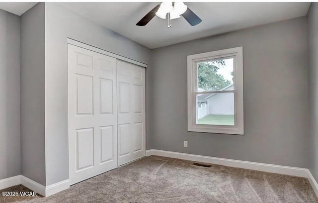 unfurnished bedroom with ceiling fan, light colored carpet, and a closet