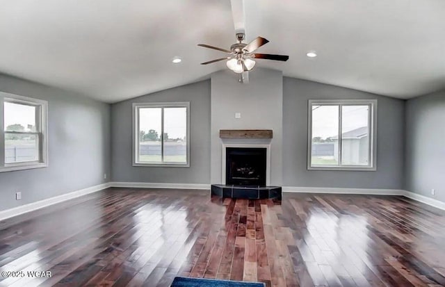 unfurnished living room with dark wood-type flooring, vaulted ceiling, and a wealth of natural light