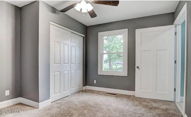 unfurnished bedroom featuring light colored carpet, a closet, and ceiling fan