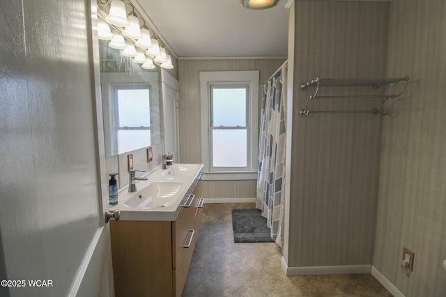 full bath featuring baseboards, double vanity, a sink, curtained shower, and crown molding