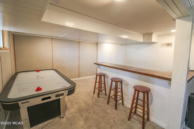 recreation room featuring visible vents, a dry bar, and carpet floors