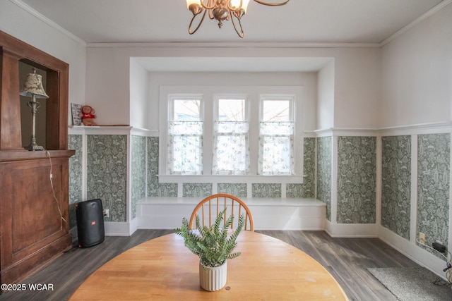 dining room with wood finished floors, an inviting chandelier, ornamental molding, and wainscoting