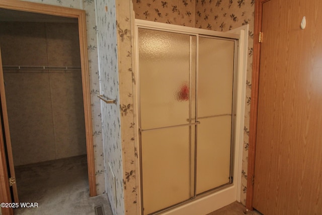 full bathroom featuring visible vents, a shower stall, and wallpapered walls