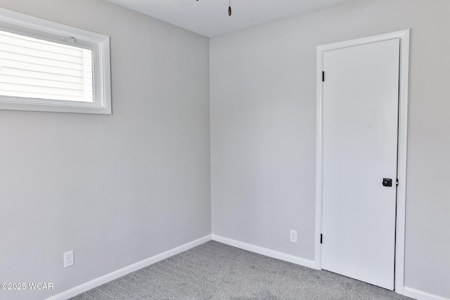 spare room featuring carpet flooring and baseboards