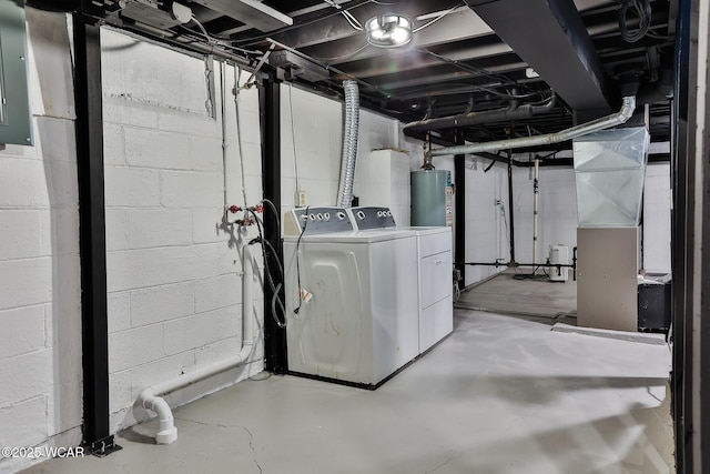 unfinished below grade area featuring heating unit, water heater, and washer and dryer