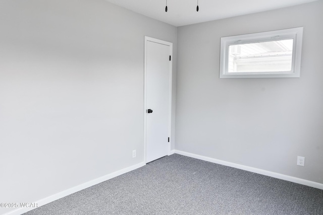 carpeted spare room with baseboards