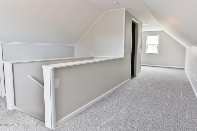 additional living space featuring lofted ceiling and carpet flooring