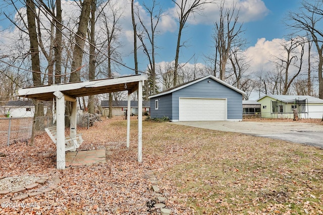 view of yard featuring a detached garage, fence, and an outdoor structure