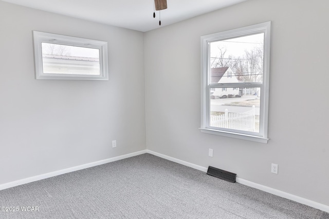 unfurnished room featuring ceiling fan, carpet, visible vents, and baseboards