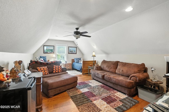 7407 Mingo Way, Russells Point, OH 43348 - living area with vaulted ceiling, light wood-style flooring, a ceiling fan, and a textured ceiling