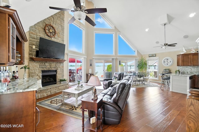 7407 Mingo Way, Russells Point, OH 43348 - living area with ceiling fan, a stone fireplace, high vaulted ceiling, and wood finished floors