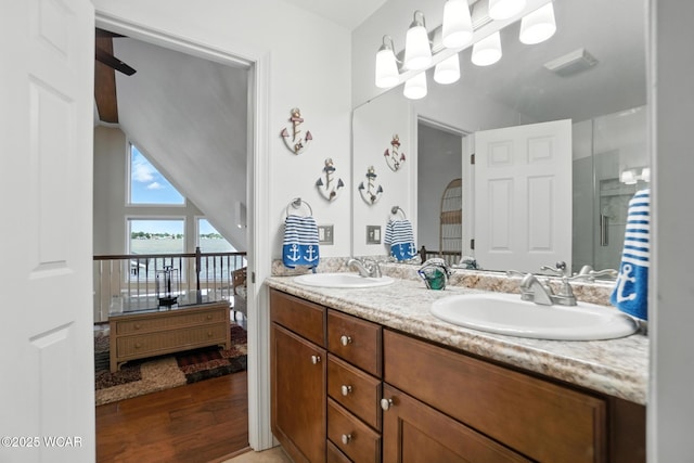 7407 Mingo Way, Russells Point, OH 43348 - bathroom featuring a water view, double vanity, lofted ceiling, and wood finished floors