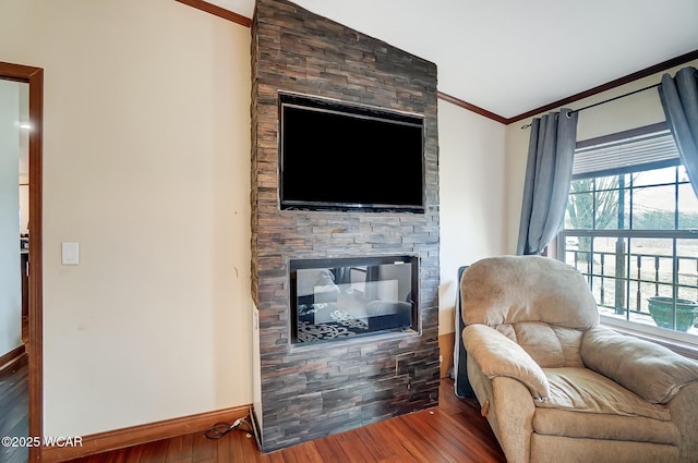 interior space featuring ornamental molding, a stone fireplace, and wood-type flooring