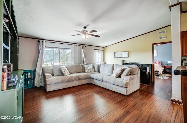 living room featuring lofted ceiling, crown molding, dark hardwood / wood-style flooring, and ceiling fan