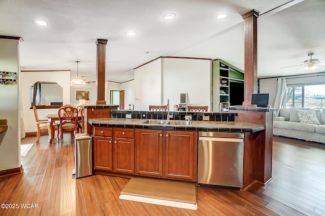 kitchen with sink, hanging light fixtures, a kitchen island, hardwood / wood-style flooring, and decorative columns