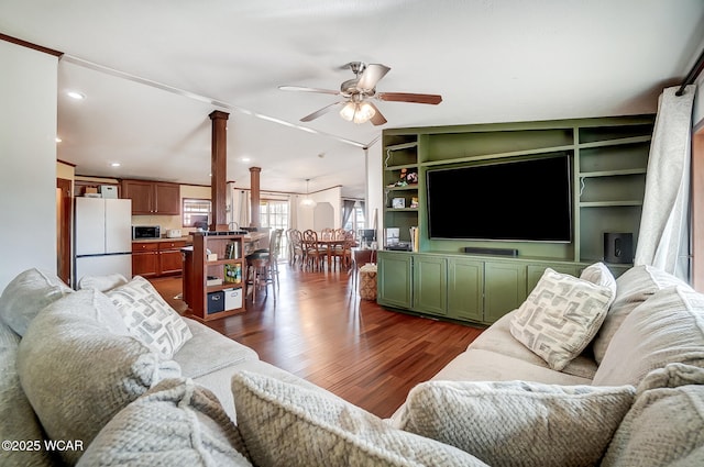 living room featuring lofted ceiling, ornate columns, dark hardwood / wood-style floors, built in features, and ceiling fan