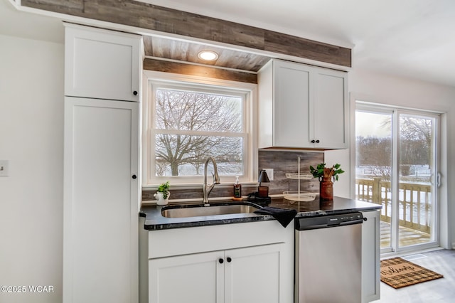 kitchen with sink, backsplash, white cabinets, and dishwasher