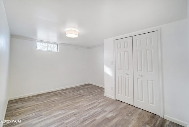 unfurnished bedroom with a closet and light wood-type flooring